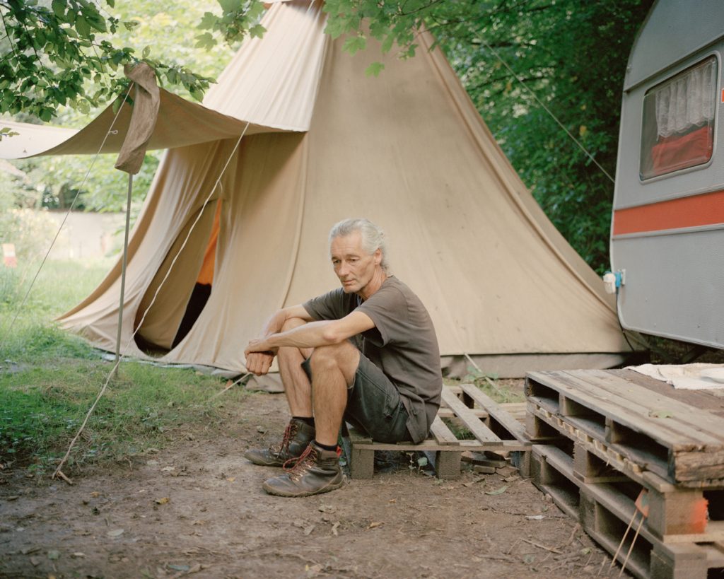 Fred sitzt auf einer Palette vor dem Tipi in Lützerath, in dem er oft die Nacht verbringt. Gemeinsam mit vielen anderen Aktivisten vor Ort setzt er sich für den Erhalt des Dorfes ein.
